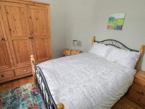 福克斯福德7 Aikenhead Terrace的一间卧室配有一张床和一个木制橱柜