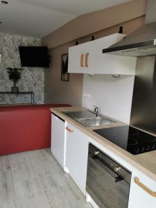 Longues-sur-MerLa chaumière的厨房配有白色橱柜和水槽