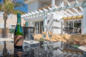 马略卡岛帕尔马Villa Sol Felostal的一瓶香槟和一张桌子上的两杯酒