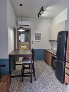 阿基欧斯尼古拉斯MOD 15 City Centre的厨房配有桌子、水槽和冰箱