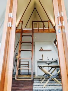塔巴南PukuPods - Tent & Cabin的一张位于带书桌和梯子的房间的阁楼床