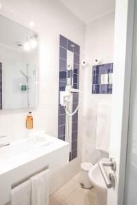 里斯本阿露比雅格兰德盘沙住宅酒店的白色的浴室设有水槽和卫生间。