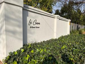 约翰内斯堡Le'Ciara Luxury Guest House的白色的墙,有单词 球場