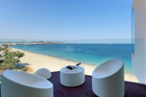 普拉亚登博萨伊维萨硬石酒店的享有海滩美景,配有2把白色椅子和1张桌子