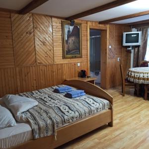 亚列姆切Guest House Grunyk的卧室配有一张床铺,位于带木墙的房间内