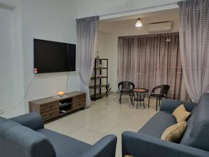 斯里曼绒Manjung CY Homey Stays The Venus Residence的客厅配有蓝色的沙发和平面电视。