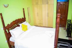 内罗毕Exquisite 1bedroom located in Garden Estate, Thome的一间卧室配有一张带黄色枕头的木床