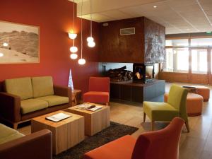 圣福瓦-塔朗泰斯Apartment close to ski lift in Sainte Foy的一间设有色彩缤纷的家具和壁炉的等候室