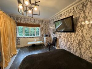 彻特西The Caduceus- Residence的卧室配有一张床,墙上配有电视