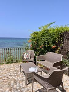 圣塔马里亚迪卡斯特Residenza Fontanelle-Beach Resort的一个带桌椅的庭院和大海