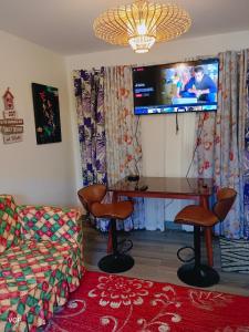 圣巴勃罗San Pablo laguna staycation的客厅配有书桌和墙上的电视。