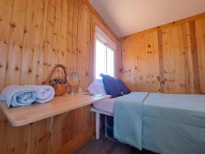 TriquivijateTiny house camión fijo en Islas Canarias的卧室设有木墙、一张床和窗户