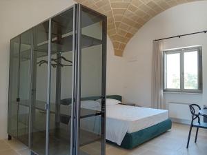 加利波利Torre Assunta Masseria的一间卧室配有玻璃淋浴间和床