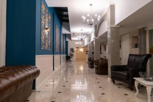 巴尔奇克白岩城堡套房酒店及SPA的长长的走廊,设有蓝色的墙壁和皮椅