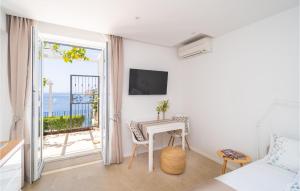 杜布罗夫尼克Beautiful Apartment In Dubrovnik With Jacuzzi的一间卧室配有一张床铺和一张桌子,并设有一个阳台