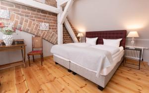 诺伊鲁平Up Hus Hotel Neuruppin的一间卧室设有一张大床和砖墙