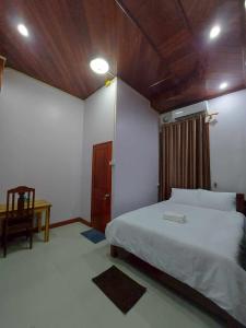 万荣Inthavong Hotel/Guest House的卧室设有白色的床和木制天花板。