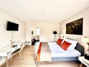 拉莫特－伯夫龙La Maison TATIN的配有一张床和一张书桌的酒店客房