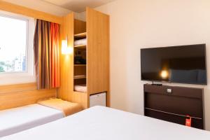 阿雷格里港宜必思博尔特阿尔格雷温托酒店的配有一张床和一台平面电视的酒店客房