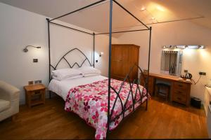 马诺比尔Tudor Lodge Bed & Breakfast的一间卧室配有一张天蓬床和一张书桌