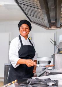 阿雷格里港宜必思博尔特阿尔格雷温托酒店的一位在厨房里准备食物的女人