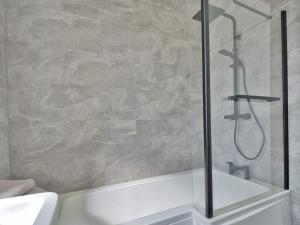 西基尔布赖德Seamill Cottage的带淋浴和白色浴缸的浴室