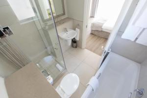 斯泰伦博斯Protea Hotel by Marriott Stellenbosch & Conference Centre的带淋浴、卫生间和盥洗盆的浴室