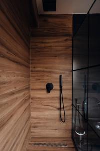 萨兰达Hotel Olsi的带淋浴的浴室(带木墙)