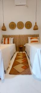 卡拉伊瓦Afeto Caraíva的卧室配有两张床,地板上铺有地毯。