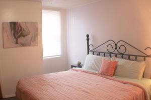 匹兹堡3 BR Southside Loft - Amazing Location的一间卧室配有一张带橙色毯子和窗户的床。
