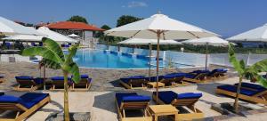 沃尔沃罗西蒙王子普莱乌公寓式酒店的一个带躺椅和遮阳伞的游泳池