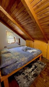 FierzëGuest House Aprripe Guri的木天花板的客房内的一张床位