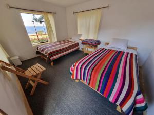 奥科苏尤Inca lodge - Amantani的客房设有两张床和窗户。