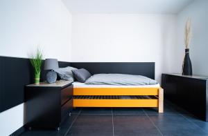 普尔海姆Blauer Stein Apartments WH1的一间卧室配有一张带黑色和橙色床头板的床
