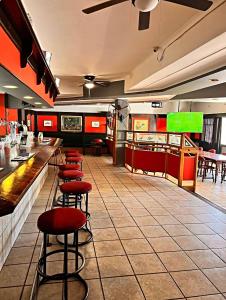 BoshoekSundown Country Estate的餐厅内带红色凳子的酒吧