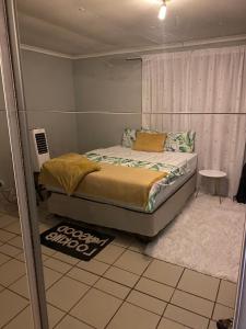 楚梅布Alvin's House的一间卧室配有一张带窗户和地毯的床