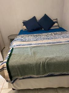 楚梅布Alvin's House的床上铺有蓝色枕头的床