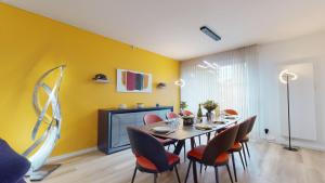 科尔马Maison Mandarine Colmar 5 bedrooms 180m2的用餐室配有桌椅和黄色墙壁
