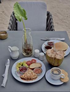 帕杰V Hotel in Paje的一张桌子,上面有一盘食物和椰子