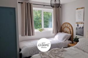 利兹ReTreat Breaks - 3 Bedroom Penthouse - Holbeck Leeds的一间卧室设有两张床和窗户。