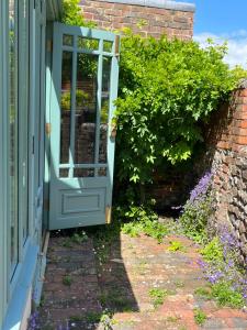 刘易斯Pretty Cottage in Central Lewes的开向鲜花盛开的花园的大门