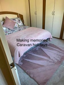 斯凯格内斯Making Memories Holiday Caravan的一间卧室配有一张带粉色毯子的床