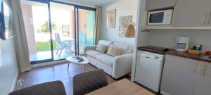 格里莫Chez Adriana Appartement Cosy avec Jardin, proche plage的厨房以及带沙发和微波炉的客厅。