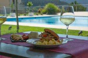 塞代拉赫贝拉酒店的一张桌子,上面放着一盘食物和一杯葡萄酒