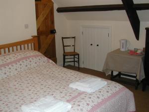 布雷肯Alltybrain Farm Cottages and Farmhouse B&B的一间卧室配有带毛巾的床