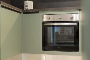 赫拉弗多纳Lisa Como lake的厨房配有绿色橱柜,配有烤箱