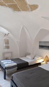 加利波利Casa Annina的一间白色客房内带两张床的卧室