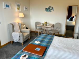 Aird UigSEAcroft Licensed B&B and Restaurant的酒店客房带一张床、一张桌子和椅子
