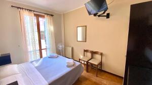 拉戈堡Umbria Green Central Rooms的一间卧室设有一张床、一台电视和一个窗口。