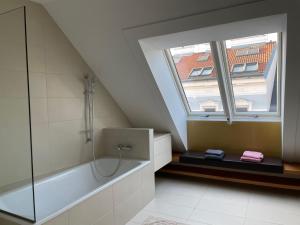 维也纳Rooftop Terrace- Panoramablick über Wien的带浴缸的浴室和窗户。